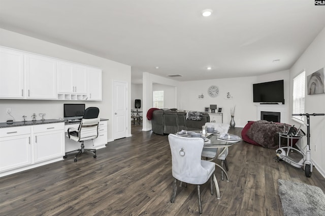 dining area featuring recessed lighting, a fireplace, dark wood-style flooring, and built in study area