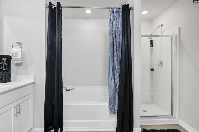 bathroom featuring a shower stall, vanity, and a garden tub