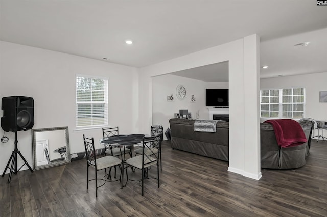 dining area with dark wood-style floors, recessed lighting, and a fireplace