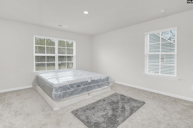 carpeted bedroom featuring visible vents, recessed lighting, and baseboards