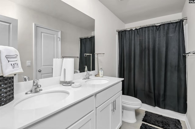 full bath featuring a sink, curtained shower, toilet, and double vanity