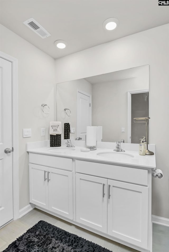 full bathroom featuring double vanity, visible vents, baseboards, and a sink