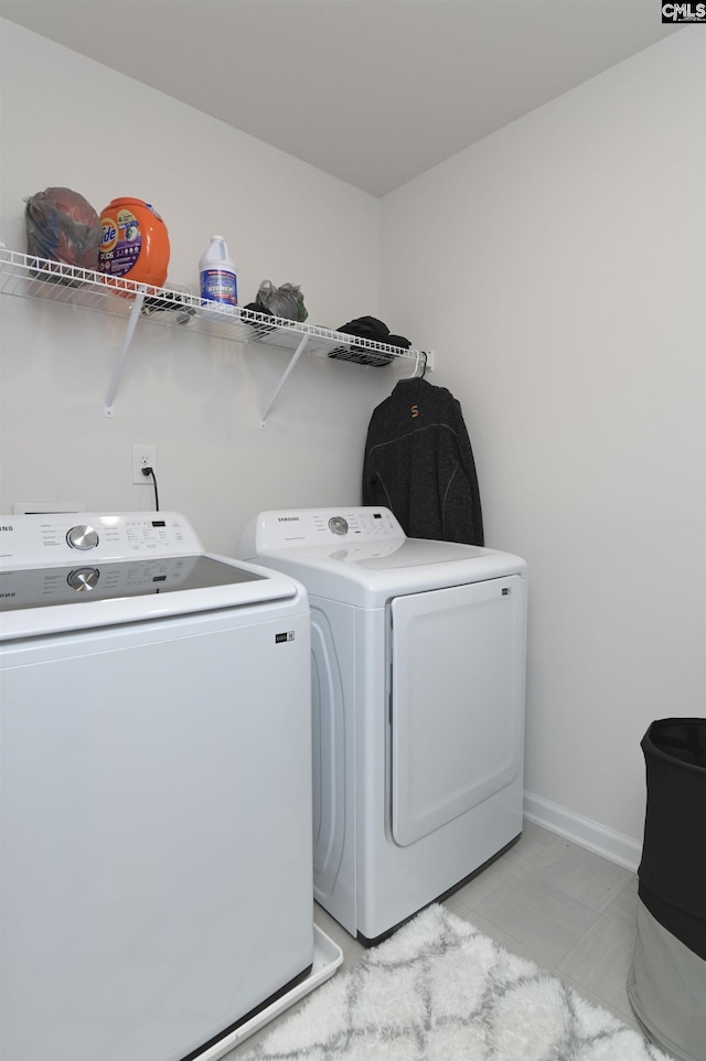 laundry area with laundry area, baseboards, and washer and clothes dryer