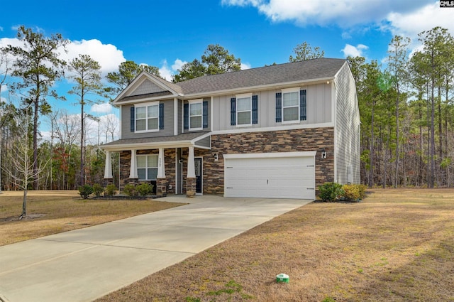 view of front of house featuring a garage, driveway, board and batten siding, and a front lawn