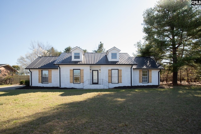 back of house featuring metal roof, brick siding, a yard, and a standing seam roof