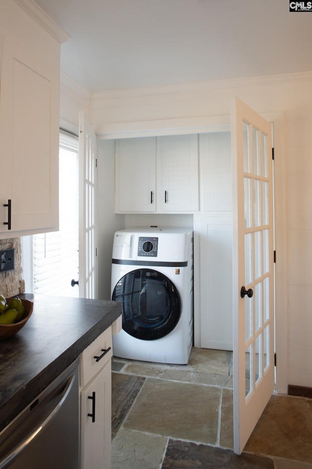 laundry area featuring cabinet space, washer / clothes dryer, stone finish flooring, crown molding, and french doors