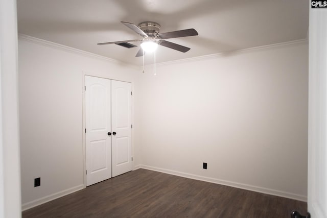 unfurnished bedroom featuring baseboards, dark wood-type flooring, and crown molding