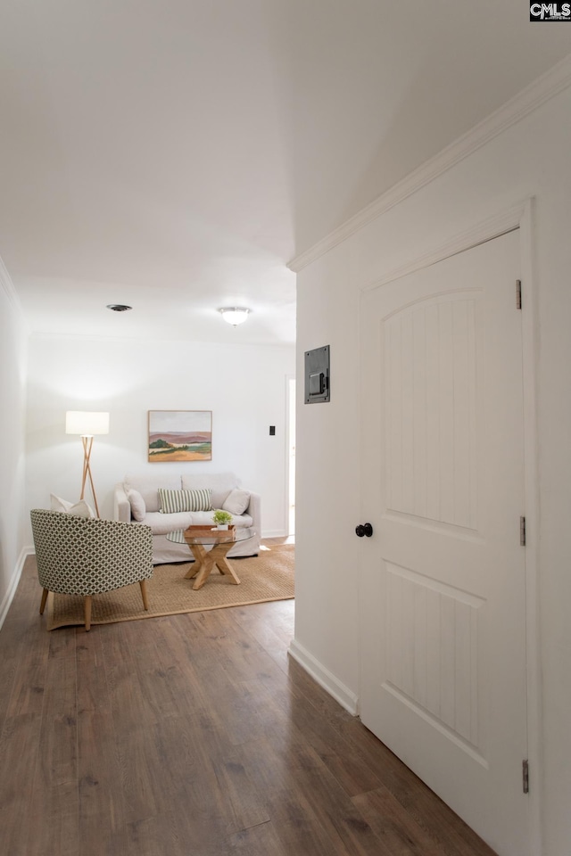 hallway featuring ornamental molding, baseboards, and wood finished floors