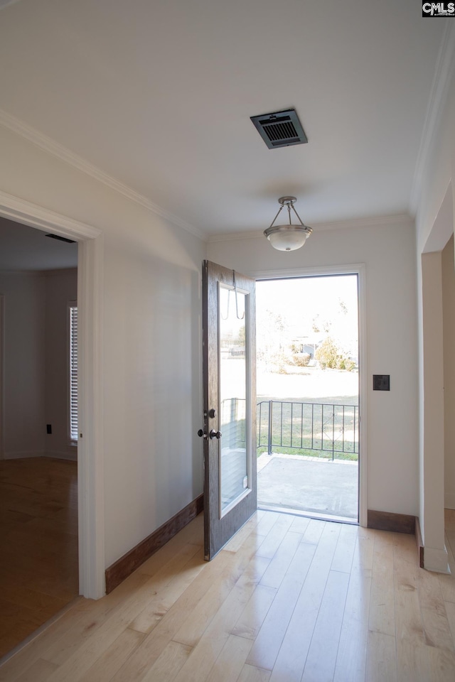 entryway featuring light wood finished floors, baseboards, visible vents, and crown molding