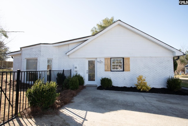 view of front of home featuring fence and brick siding