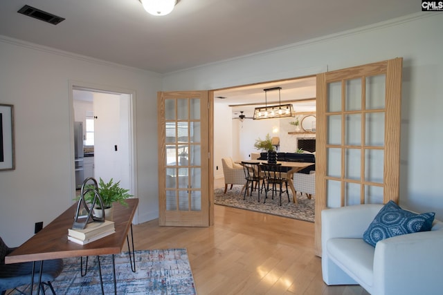 office featuring french doors, ornamental molding, wood finished floors, and visible vents