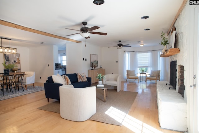 living area featuring light wood-type flooring, a fireplace, and baseboards