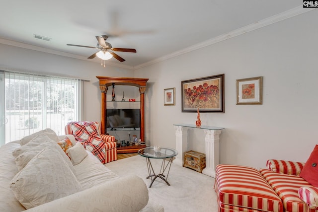 living area with ornamental molding, carpet, visible vents, and ceiling fan