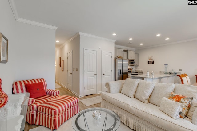 living room featuring baseboards, crown molding, light wood-type flooring, and recessed lighting