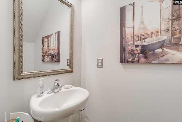 bathroom with a soaking tub and a sink