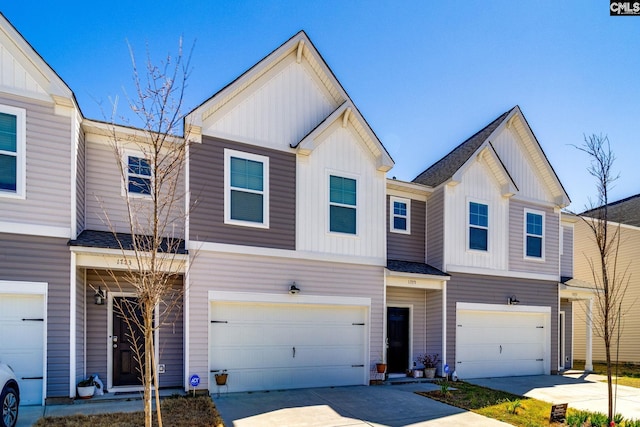 townhome / multi-family property with driveway, an attached garage, board and batten siding, and roof with shingles