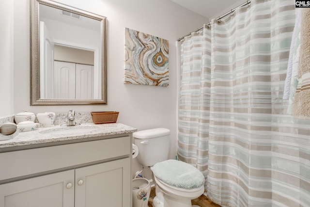 bathroom with toilet, visible vents, and vanity