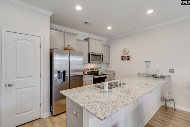 kitchen featuring visible vents, a peninsula, gray cabinets, stainless steel appliances, and a sink