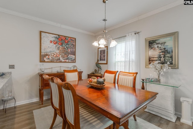 dining space with crown molding, light wood-style flooring, and a notable chandelier