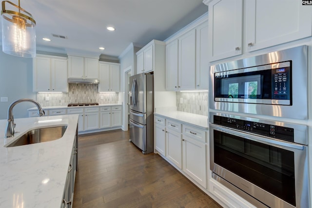 kitchen with under cabinet range hood, stainless steel appliances, a sink, white cabinetry, and visible vents