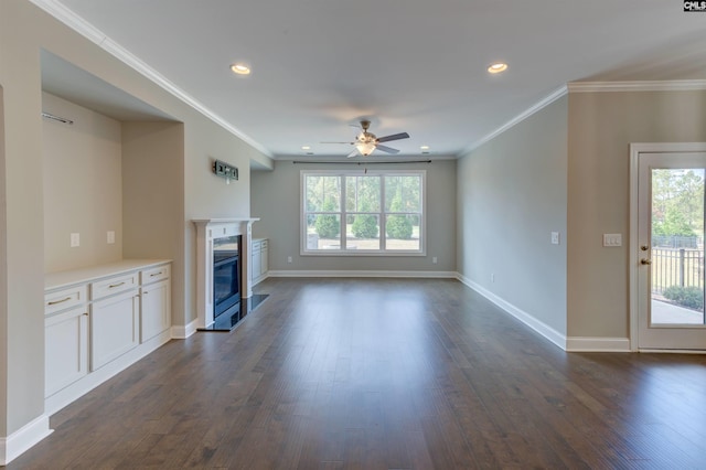 unfurnished living room featuring ornamental molding, dark wood-style flooring, a glass covered fireplace, and baseboards