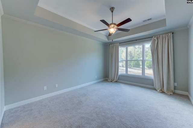 empty room featuring baseboards, a tray ceiling, carpet flooring, and ornamental molding