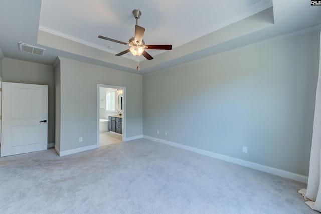 unfurnished bedroom featuring crown molding, a tray ceiling, visible vents, and baseboards