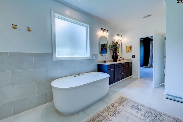 bathroom with a freestanding bath, double vanity, a sink, and crown molding