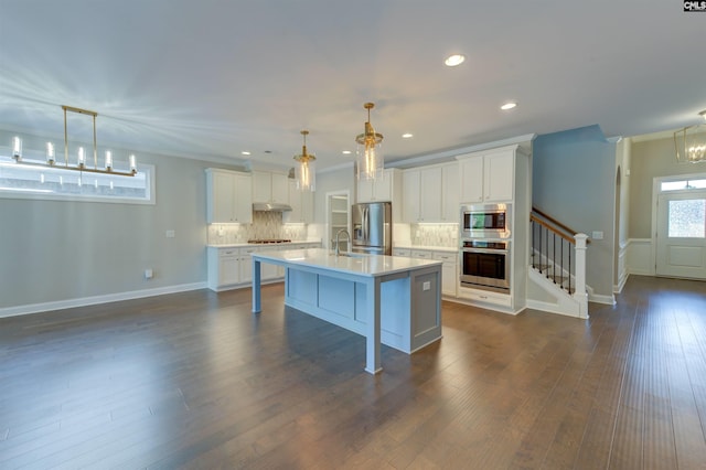 kitchen featuring stainless steel appliances, light countertops, a sink, and decorative backsplash