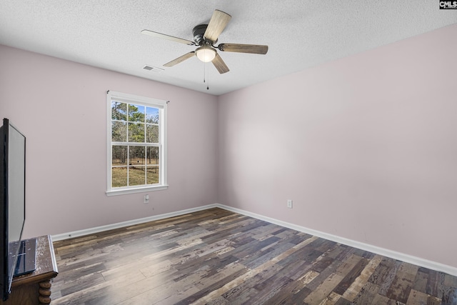 spare room with baseboards, a textured ceiling, visible vents, and wood finished floors