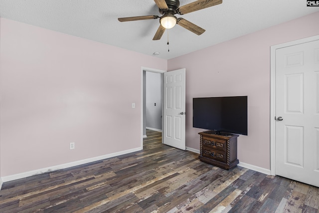 unfurnished bedroom featuring dark wood-style floors, ceiling fan, baseboards, and a textured ceiling