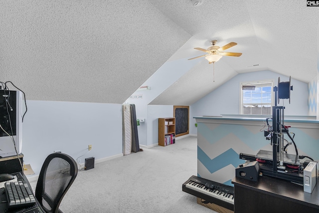 carpeted office space with a textured ceiling, ceiling fan, visible vents, baseboards, and vaulted ceiling