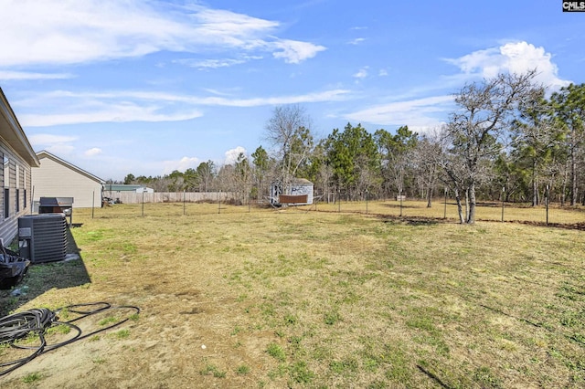 view of yard featuring fence and central air condition unit