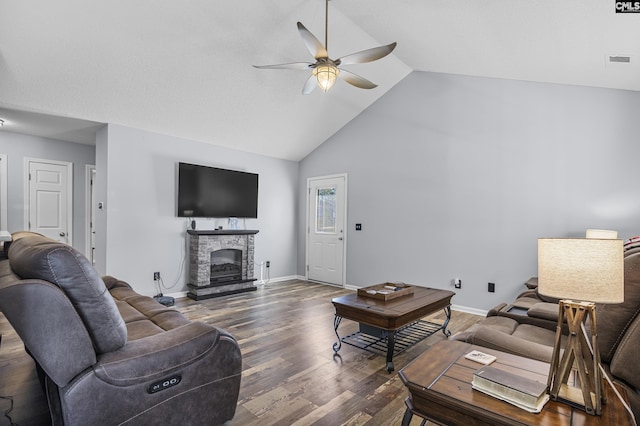 living room featuring visible vents, ceiling fan, a stone fireplace, wood finished floors, and baseboards