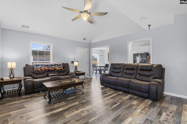 living room featuring visible vents, vaulted ceiling, wood finished floors, baseboards, and ceiling fan with notable chandelier