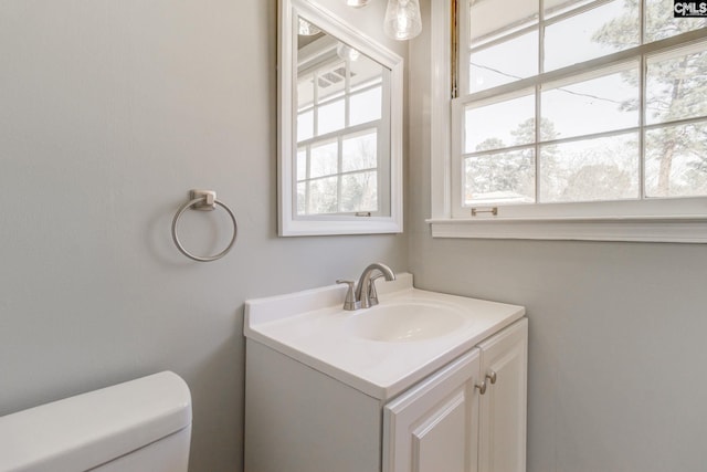 half bathroom with vanity and toilet