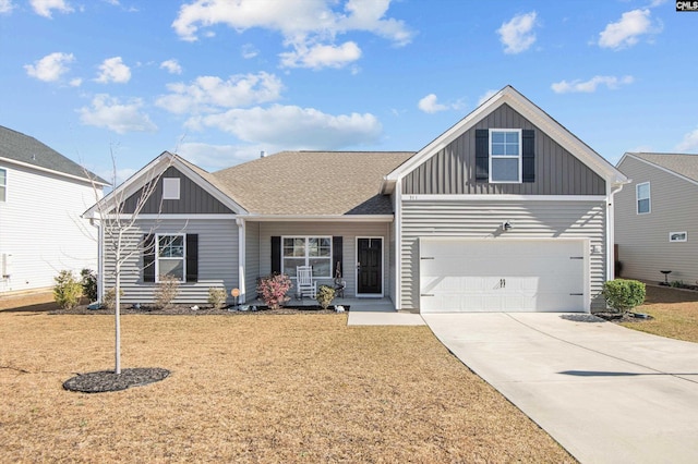 view of front facade featuring board and batten siding, a front yard, driveway, and a shingled roof