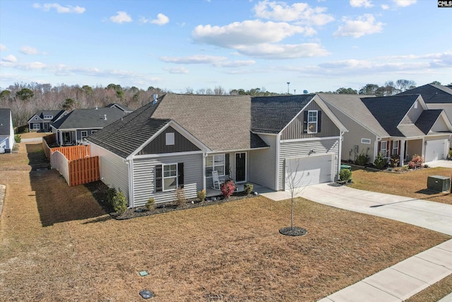 view of front of house featuring board and batten siding, a front yard, and driveway