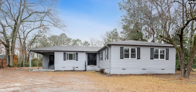 view of front of property featuring an attached carport, crawl space, and dirt driveway