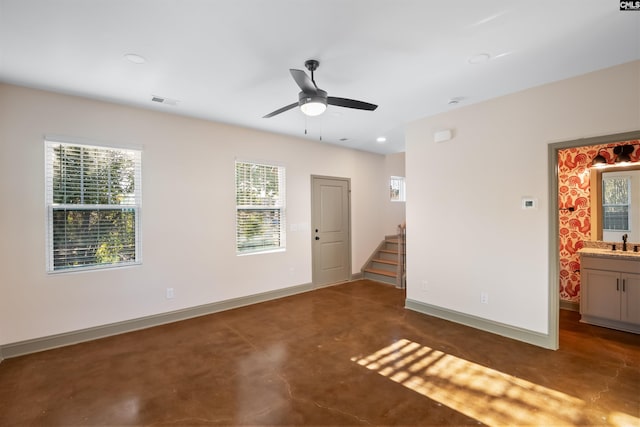 unfurnished room featuring visible vents, stairway, a sink, concrete floors, and baseboards