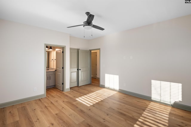 unfurnished bedroom with a ceiling fan, light wood-style flooring, baseboards, and connected bathroom