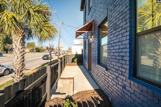 view of home's exterior with brick siding and fence