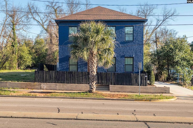 view of front of house with a fenced front yard and brick siding