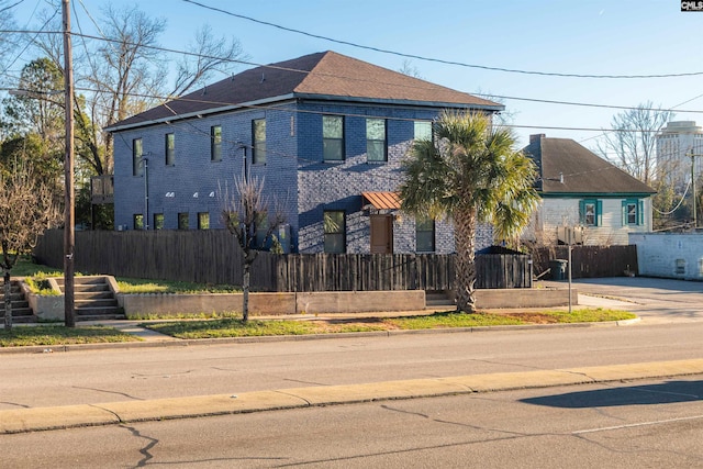 view of front of home with a fenced front yard and brick siding