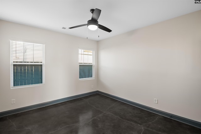 unfurnished room with ceiling fan, concrete floors, and baseboards