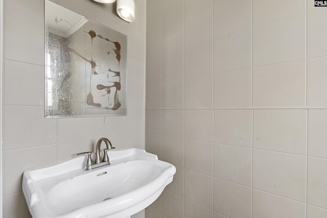 bathroom featuring tile walls and a sink