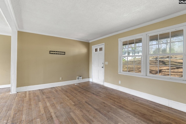 unfurnished room with ornamental molding, a textured ceiling, and wood finished floors