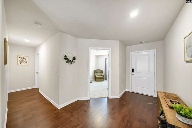 foyer entrance featuring dark wood-style floors, baseboards, and visible vents