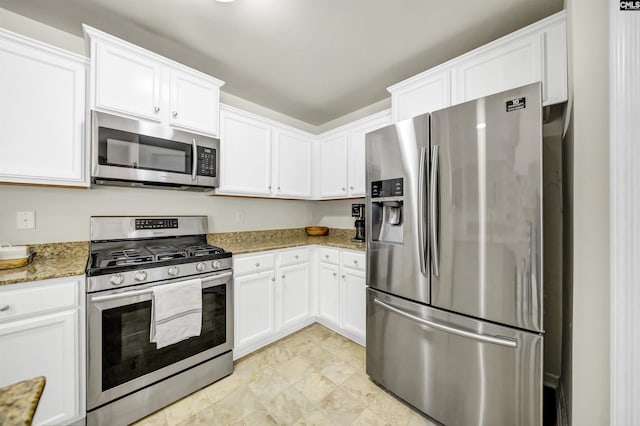 kitchen with appliances with stainless steel finishes, white cabinets, and light stone counters