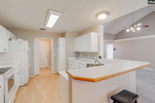 kitchen featuring lofted ceiling, a breakfast bar, a sink, visible vents, and white electric range oven